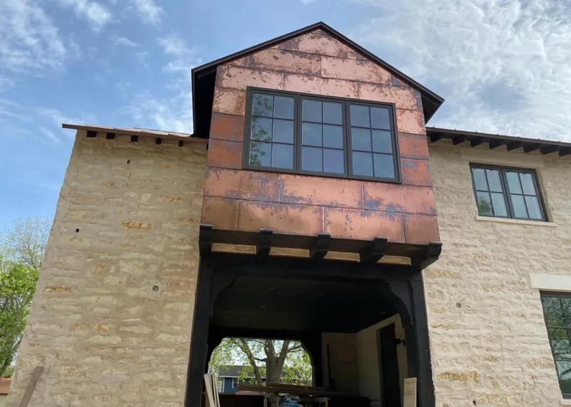 Copper metal panel facade on a stone building for Skylight Installation in Wilkins